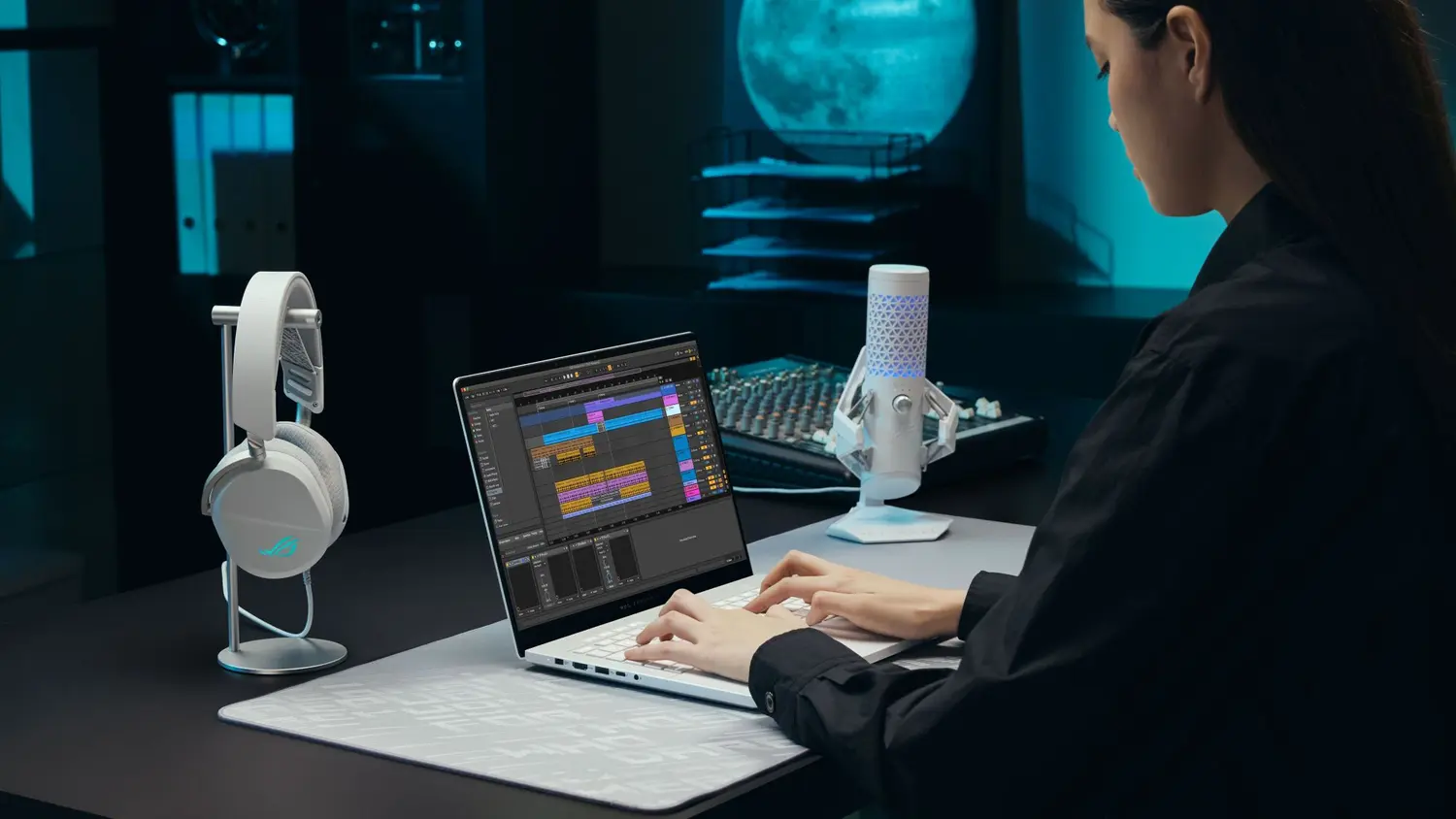 Seorang kreator menggunakan ASUS ROG Zephyrus G14 di meja produksi audio